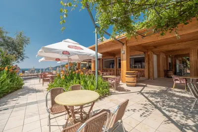 a patio with tables and chairs and an umbrella at Hotel Montenegro in Budva