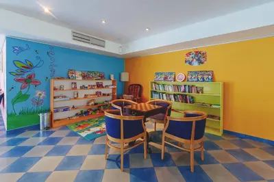 a room with a table and chairs and a book shelf at Hotel Montenegro in Budva