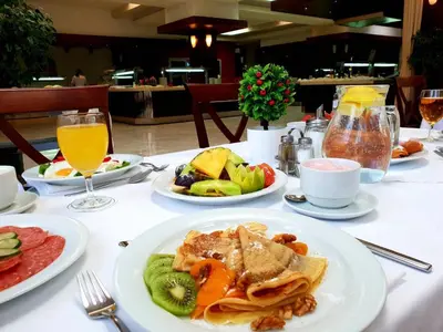 a white table topped with plates of food and drinks at Hotel Montenegro in Budva