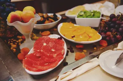 a table topped with plates of fruit and bowls of food at Hotel Montenegro in Budva