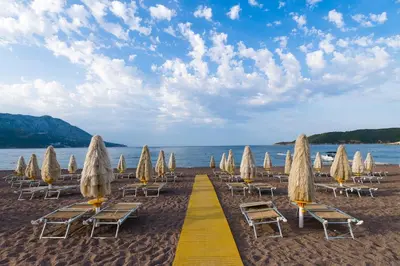 a group of chairs and umbrellas on a beach at Splendid Conference & Spa Resort in Budva