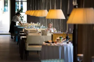 a woman sitting at a table in a restaurant at Splendid Conference & Spa Resort in Budva