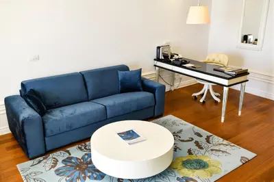 a living room with a blue couch and a desk at Splendid Conference & Spa Resort in Budva