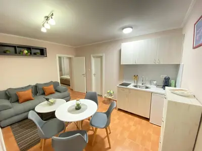 a living room with a couch and a table and chairs at Aquata Apartments in Tivat