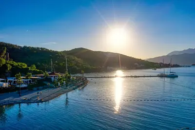 a view of a body of water with the sun setting at Aquata Apartments in Tivat