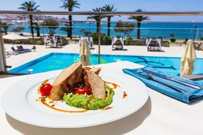 a plate of food on a table next to a pool at Hotel Princess in Bar