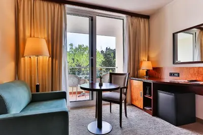 a hotel room with a table and a chair and a living room at Hotel Princess in Bar