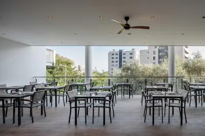 a restaurant with tables and chairs and a ceiling fan at Eurostars Queen of Montenegro in Budva
