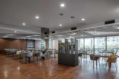 a dining room with tables and chairs and windows at Eurostars Queen of Montenegro in Budva