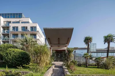 a building with palm trees in front of it at Eurostars Queen of Montenegro in Budva