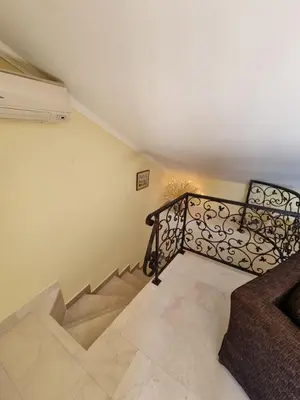 a staircase with a wrought iron railing in a room at Seaview Apartments VERA in Petrovac na Moru