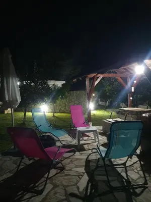 a group of chairs sitting on a patio at night at Green House Pejovic in Podgorica