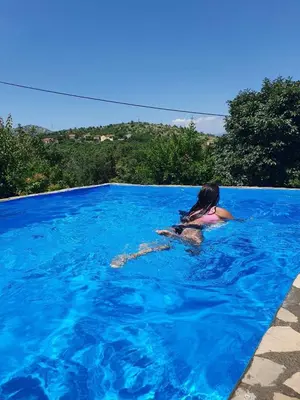 a woman is swimming in a swimming pool at Green House Pejovic in Podgorica