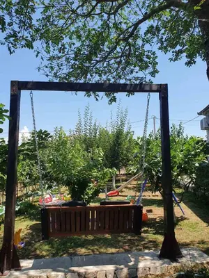 a swing in a garden with a tree at Green House Pejovic in Podgorica