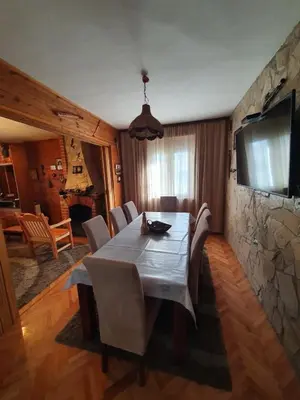 a dining room with a table and a stone wall at Green House Pejovic in Podgorica
