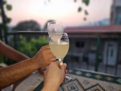 a person holding a glass of white wine at Apartments 