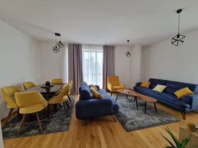 a living room with a blue couch and a table at Your second home in Podgorica in Podgorica