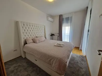 a bedroom with a large bed with a large headboard at Your second home in Podgorica in Podgorica