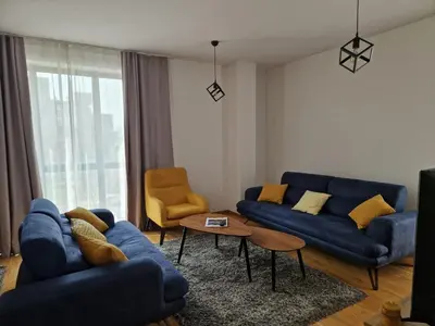 a living room with blue couches and a table at Your second home in Podgorica in Podgorica