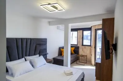a bedroom with a white bed and a couch at Sand Apartments in Ulcinj