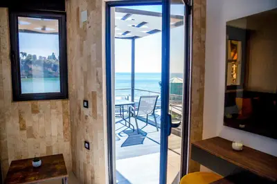 a room with a balcony with a view of the ocean at Sand Apartments in Ulcinj