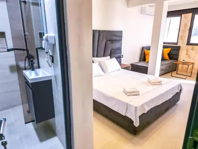 a small bedroom with a bed and a shower at Sand Apartments in Ulcinj