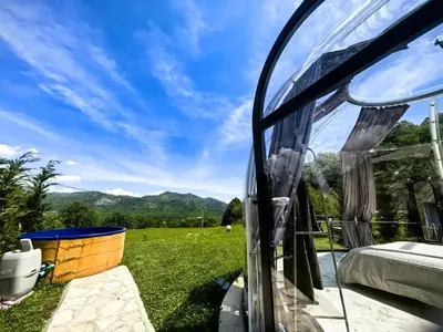 a glass room with a view of the mountains at ZEN Relaxing Village in Cetinje