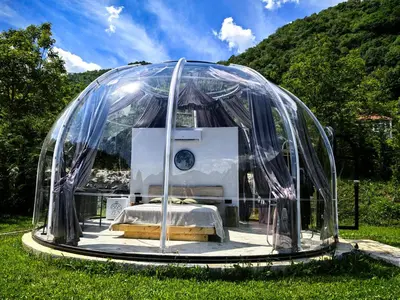 a bed in a glass dome in a field at ZEN Relaxing Village in Cetinje
