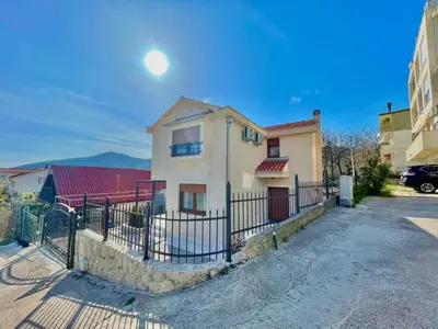 a house with a fence in front of a street at Villa Serenity Budva in Budva
