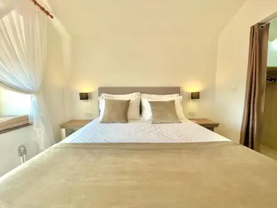 a bedroom with a large bed with white sheets and pillows at Villa Serenity Budva in Budva