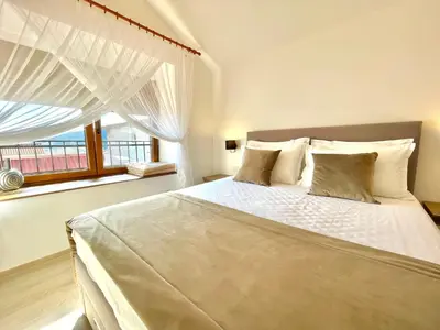 a bedroom with a large white bed with a window at Villa Serenity Budva in Budva
