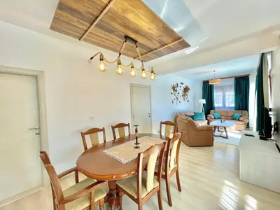 a dining room and living room with a table and chairs at Villa Serenity Budva in Budva