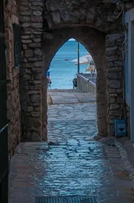an archway in a stone building with a view of the ocean at Hotel Astoria in Budva