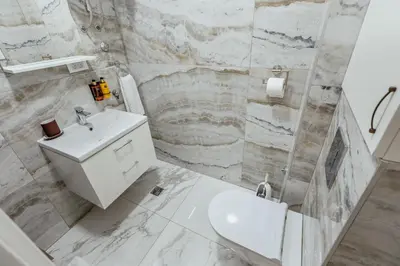 a white bathroom with a sink and a shower at APARTLU in Kotor