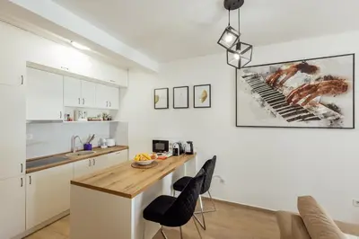 a kitchen with a table and two black chairs at APARTLU in Kotor