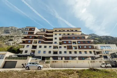 a large building with a car parked in front of it at APARTLU in Kotor
