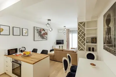 a kitchen and living room with a table and chairs at APARTLU in Kotor