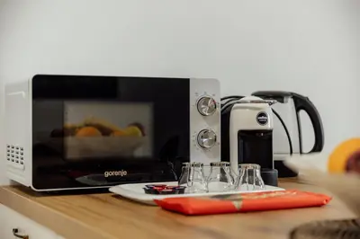 a microwave sitting on top of a counter with glasses at APARTLU in Kotor
