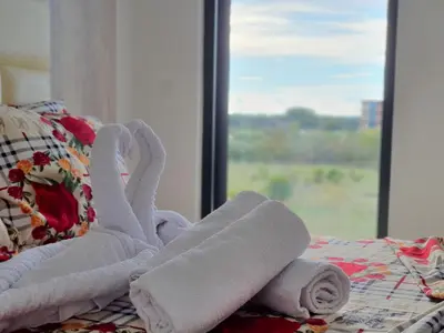 a pile of towels on a bed with a window at Apartments Alsa in Ulcinj
