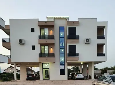 a building with cars parked in front of it at Apartments Alsa in Ulcinj
