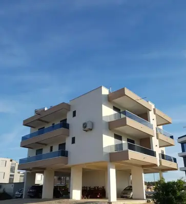 a white building with blue balconies on it at Apartments Alsa in Ulcinj