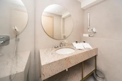 a bathroom with a sink and a mirror at Hotel Pima Budva in Budva