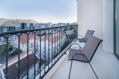 a balcony with two chairs and a view of a city at Hotel Pima Budva in Budva