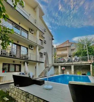 a hotel with a swimming pool in front of a building at Apartments TP 777 in Budva