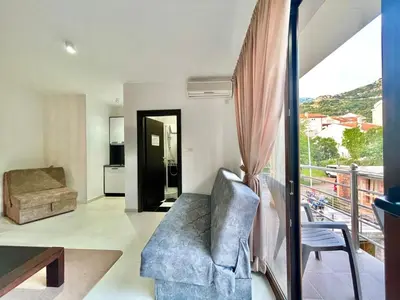 a living room with a couch and a balcony at Apartments TP 777 in Budva