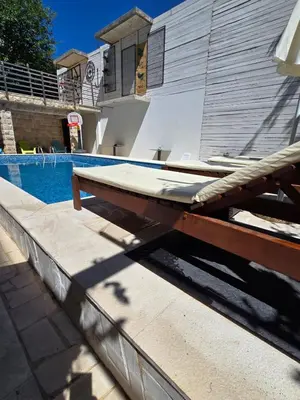 a swimming pool with a wooden table next to a swimming pool at Apartments TP 777 in Budva