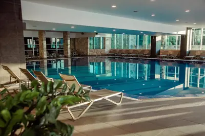 a large swimming pool with chairs in a building at Avala Resort & Villas in Budva