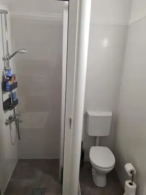 a small bathroom with a toilet and a shower at Top floor with stunning seaview, first line in Rafailovici