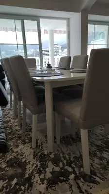 a table and chairs in a room with windows at Top floor with stunning seaview, first line in Rafailovici