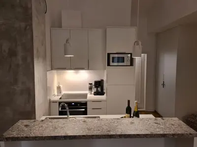 a kitchen with white cabinets and a counter top at Top floor with stunning seaview, first line in Rafailovici